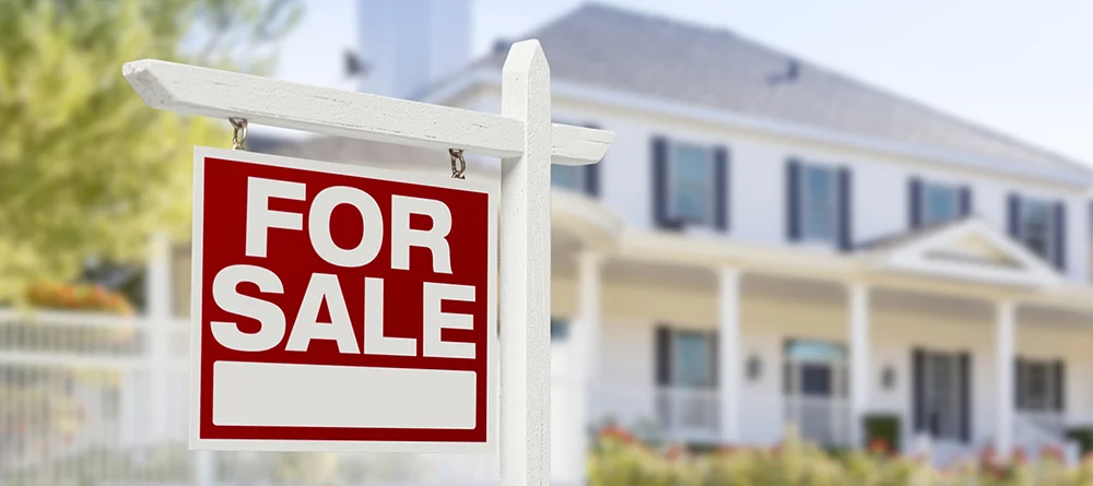 Home For Sale Real Estate Sign in Front of Beautiful New House.